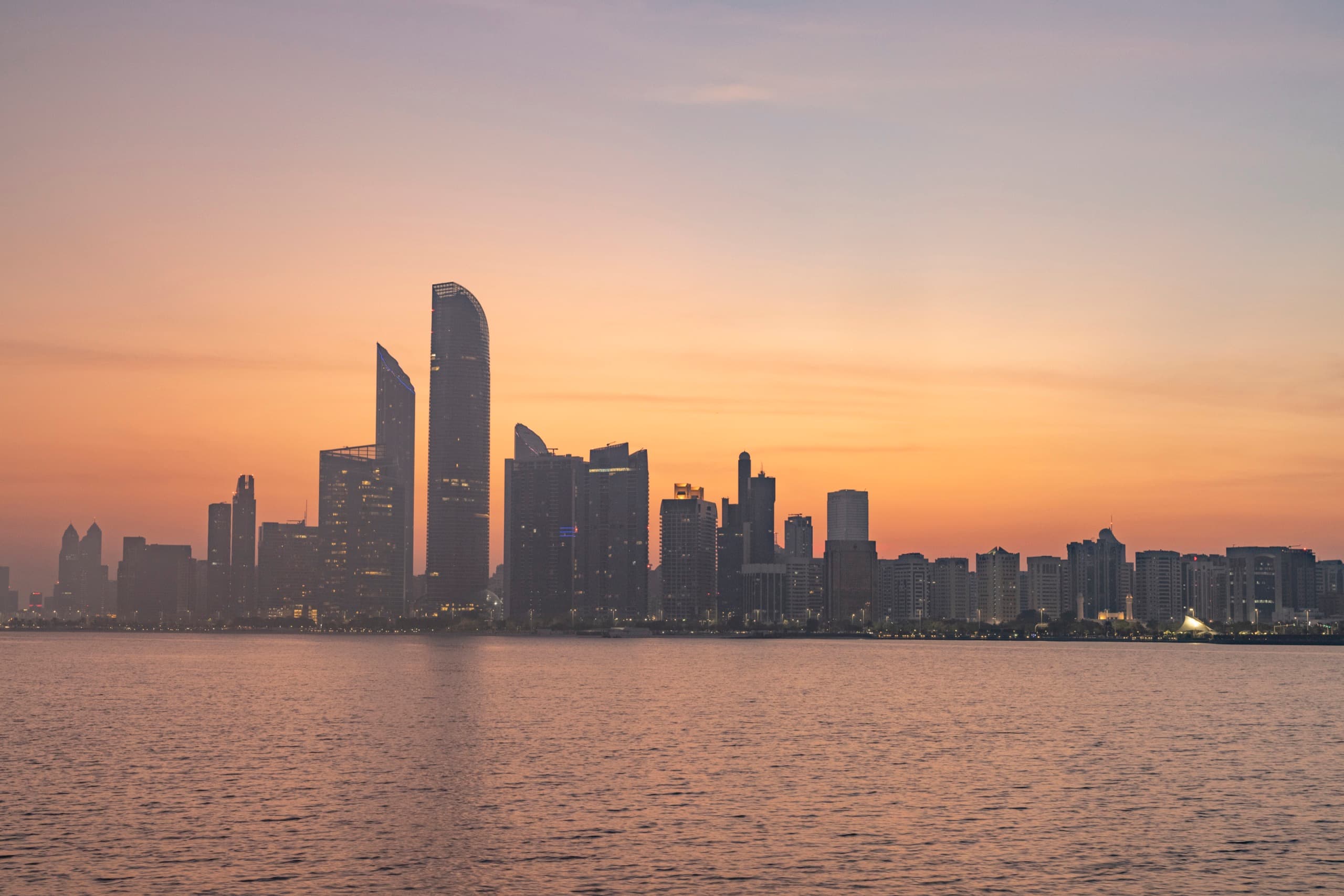 The Abu Dhabi skyline across the water at sunset