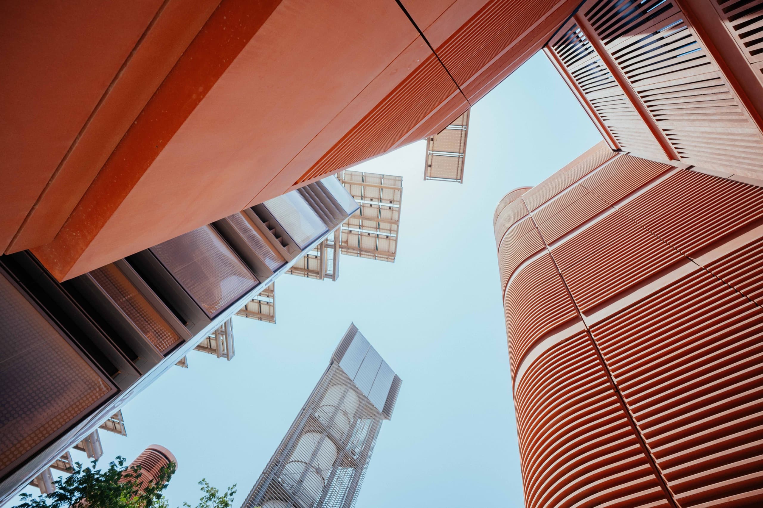 Masdar City's terracotta facades and wind tower seen from below