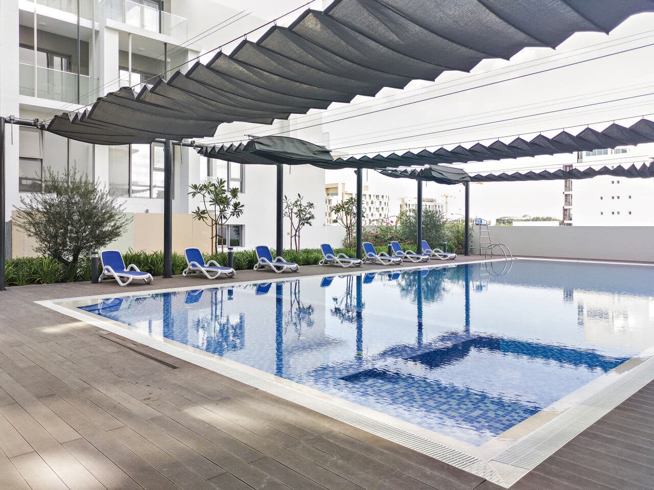 The Oasis 1 pool under its shade sails, apartment balconies around it