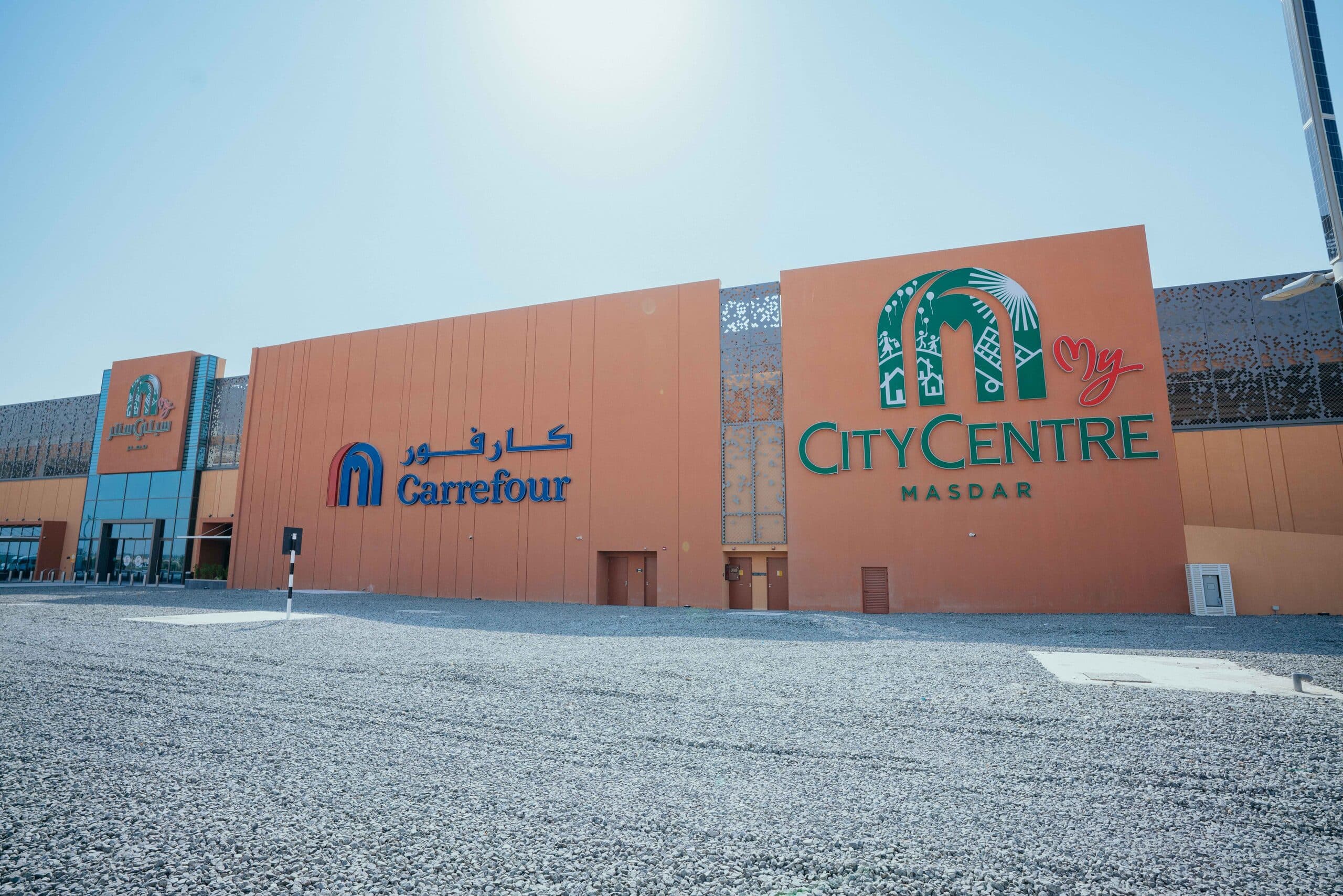 The terracotta front of My City Centre Masdar under a clear sky