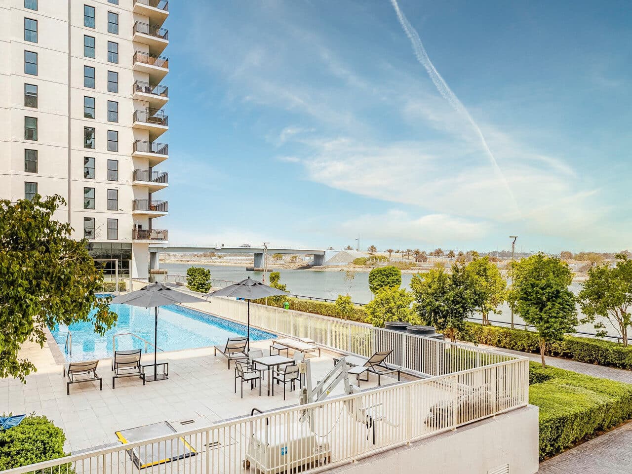 A Water's Edge courtyard pool beside the canal, an apartment tower on the left